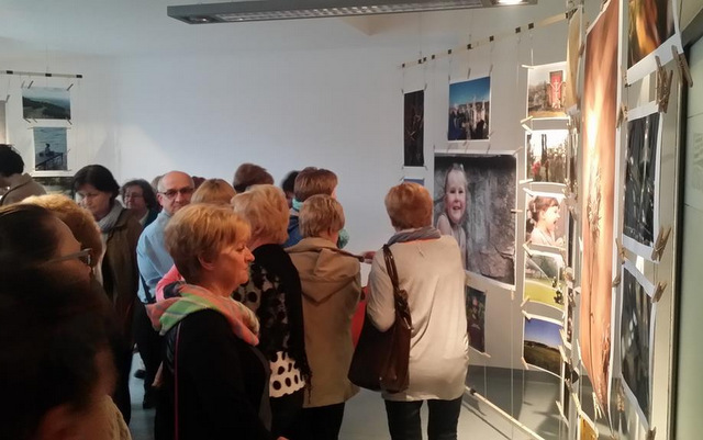Odwiedzający wystawę podziwiają zdjęcia