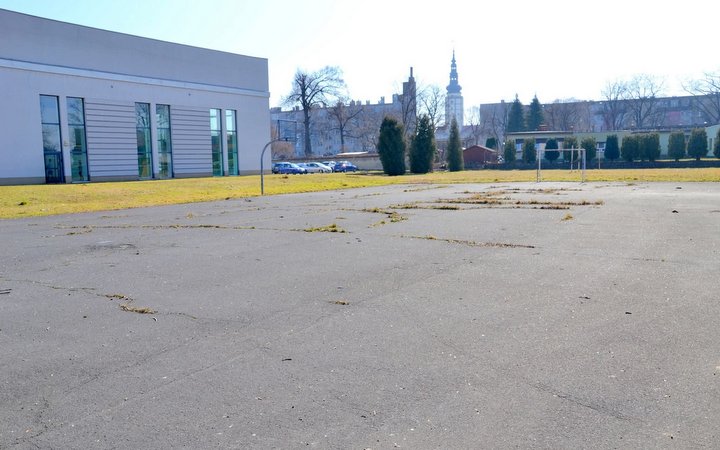 Obecny stan betonowego boiska przy LO Strzelin. Powstaną tu nowoczesny kompleks sportowy: boisko wielofunkcyjne, kort tenisowy, ścianka treningowa, boisko do padla i siatkówki plażowej oraz nowa bieżnia i szatnia