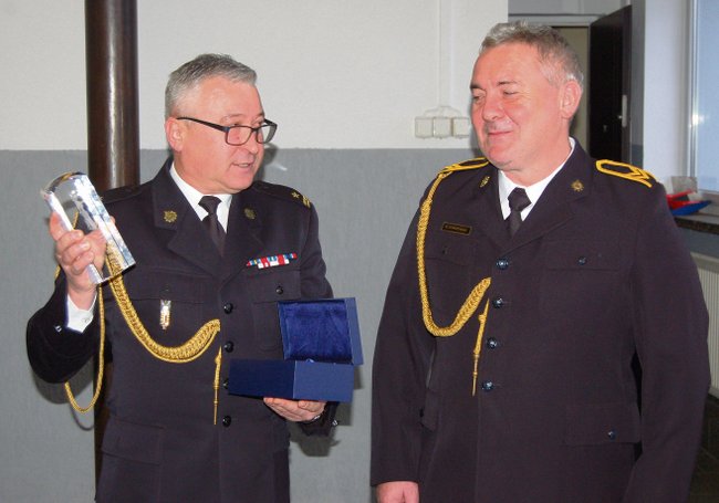 Komendant PSP Krzysztof Dobrowolski (z lewej) przekazał Bogusławowi Dorczyńskiemu pamiątkowy upominek