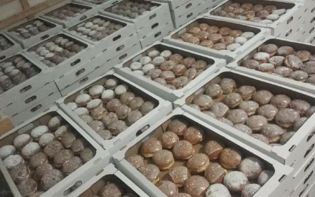 Pączki starannie pakowane są do pudełek, które trafią rano do sklepu Pączki starannie pakowane są do pudełek, które trafią rano do sklepu