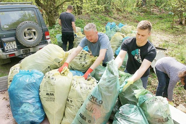 Mężczyźni ładowali na przyczepę góry worków